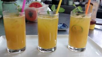 Kolme lasillista keltaista juomaa valkoisella tarjottimella.