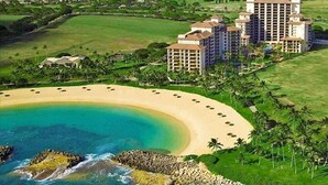 Un resort con spiaggia, diversi edifici a più piani e un campo da golf.