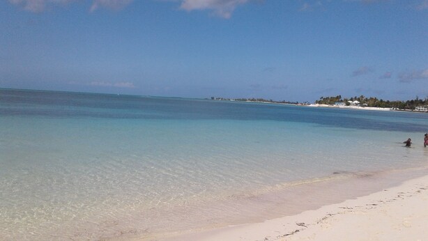 A beach with clear turquoise water and a sandy shore. - Cedar Pine Villas - Quiet, 'Luxury & Comfort Rolled Into One' (Nassau)