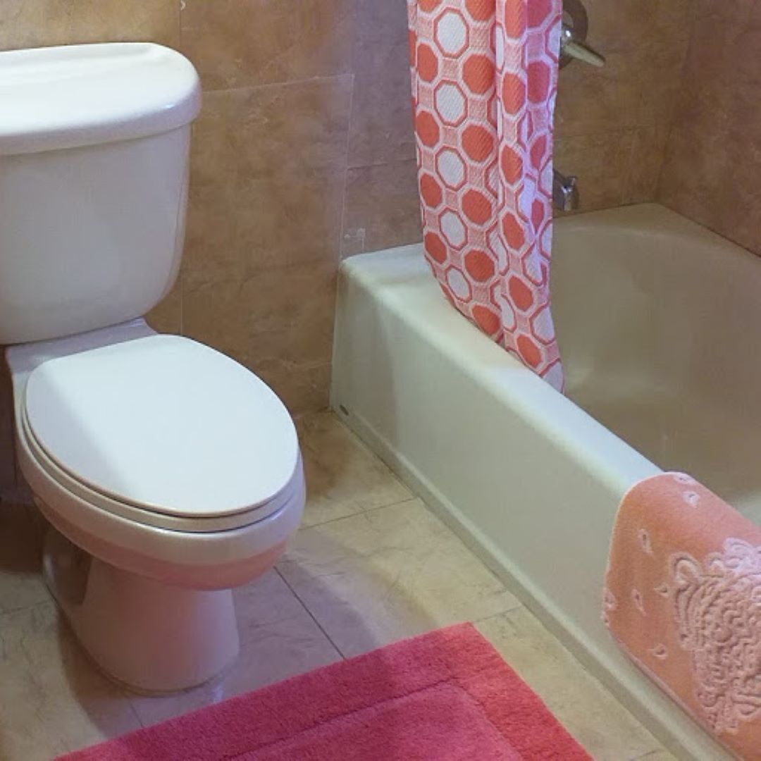 Un baño con inodoro, bañera y cortina de ducha.