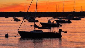 A marina with multiple boats anchored during sunset. - Jamestown: Cozy Coastal Cottage in town near beaches & Newport, dogs OK! (Jamestown)