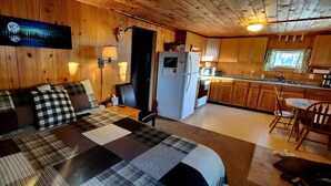 Een knus vakantiehuis met een bed, een keuken en een eethoek.