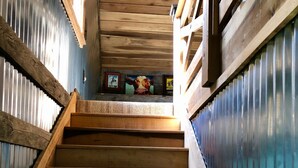 A wooden staircase with a handrail, leading to a landing with framed pictures. - Unique farm guest house close to Chattanooga, TN- great for families and dogs (Chickamauga)