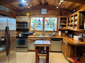 Een koelkast met diepvriezer, een microgolfoven, een oven, een kookplaat