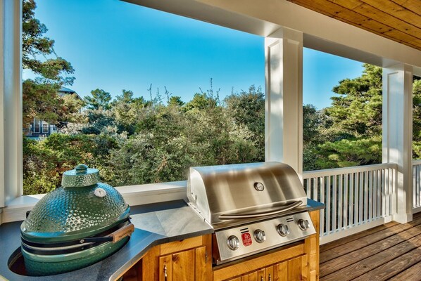 A covered outdoor area with a grill and a smoker.