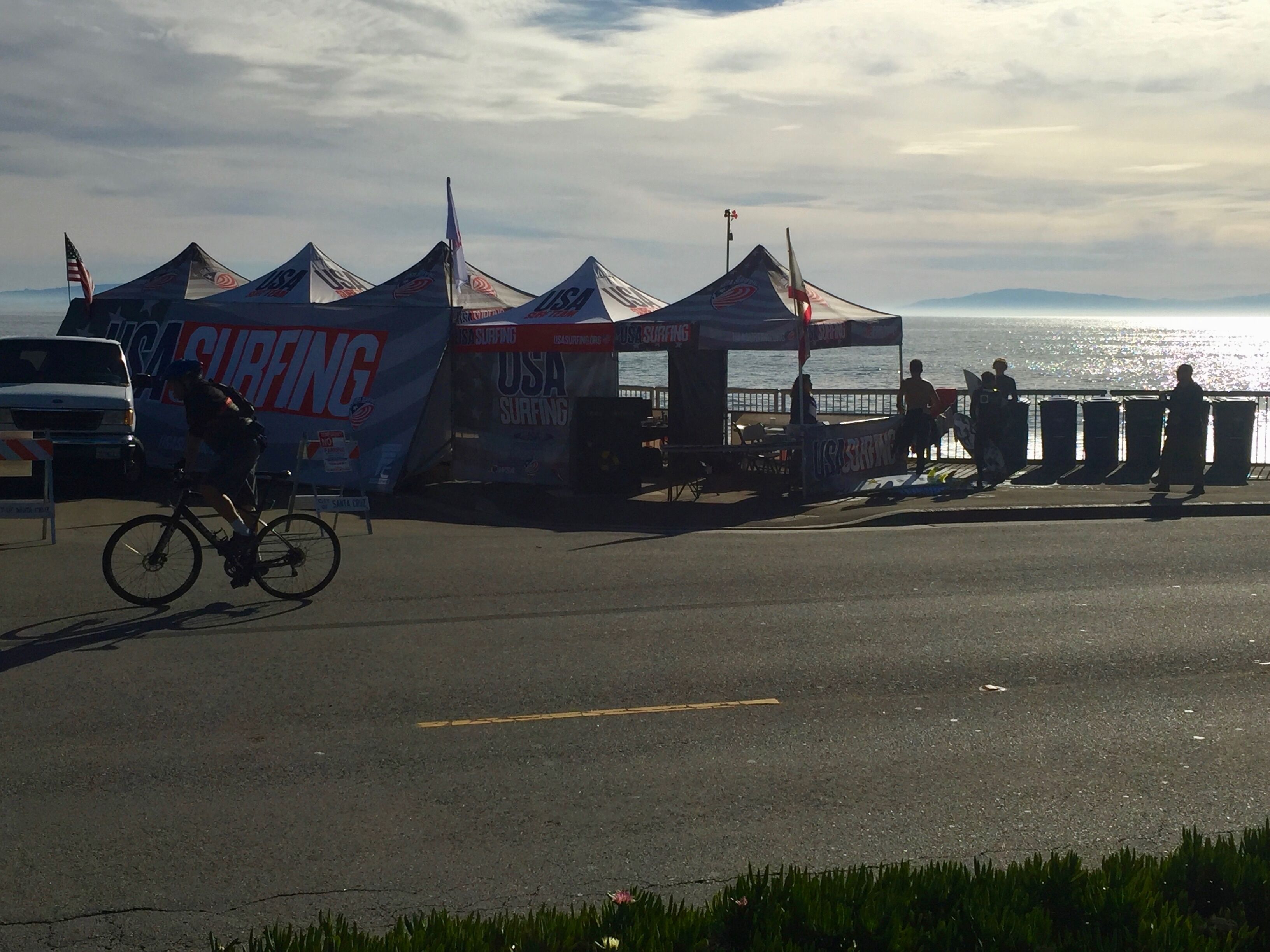 A coastal area with tents labeled "USA Surfing" and a bicycle in the foreground.