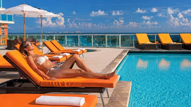 Een zwembadgedeelte met ligbedden en uitzicht op zee.