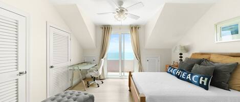 Une chambre à coucher avec un lit, un bureau et une vue sur l’extérieur.