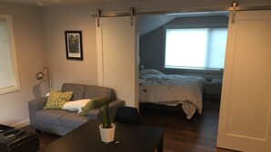 Ein gemütlicher Wohnbereich mit Sofa, Esstisch und Bett.