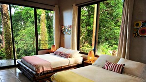 Una habitación con dos camas, ventanas amplias y vistas a zonas verdes.