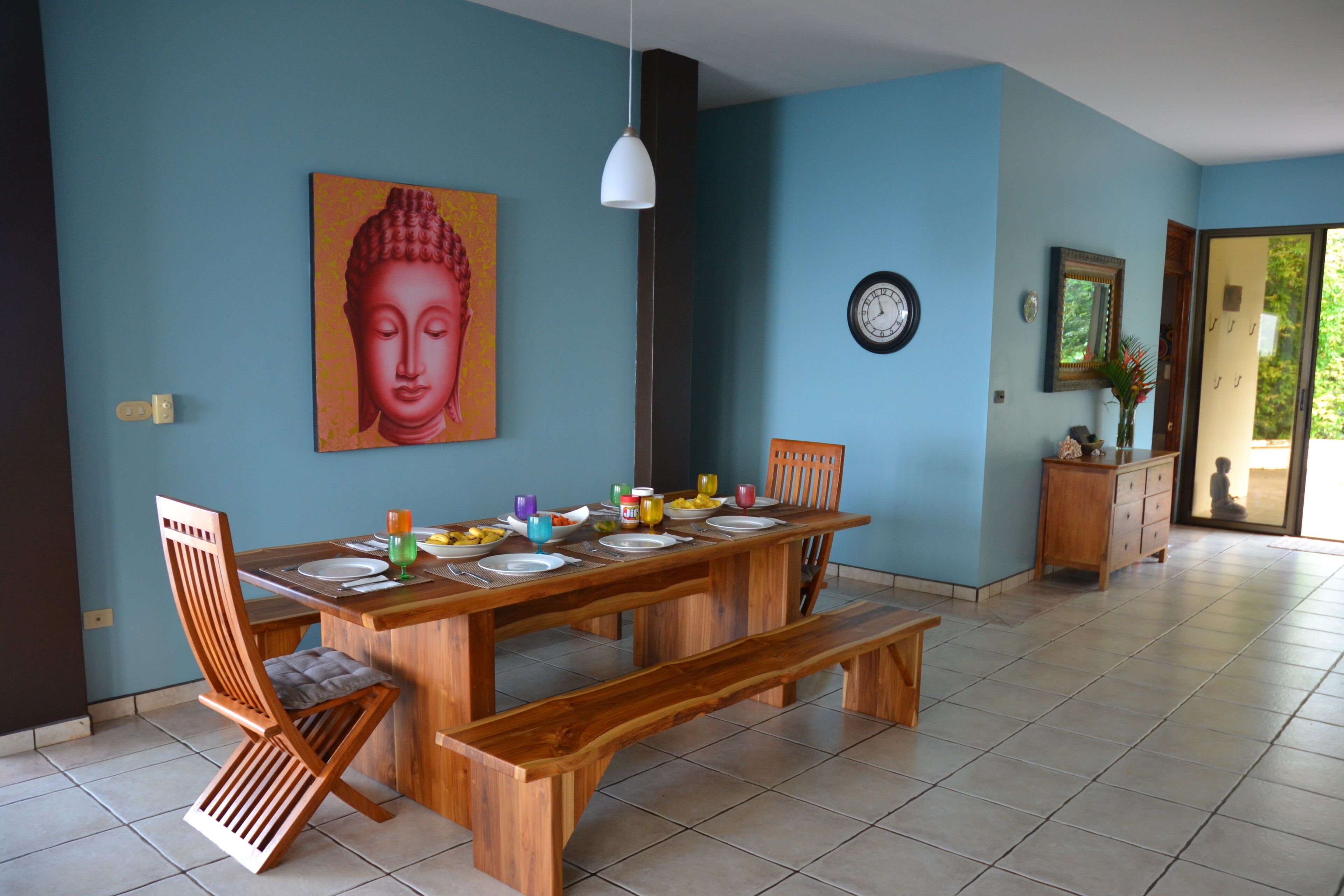 Un espace repas avec une table en bois dressée pour quatre personnes, des bancs et des chaises.