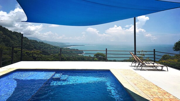 Una piscina con vistas al océano y a las montañas.