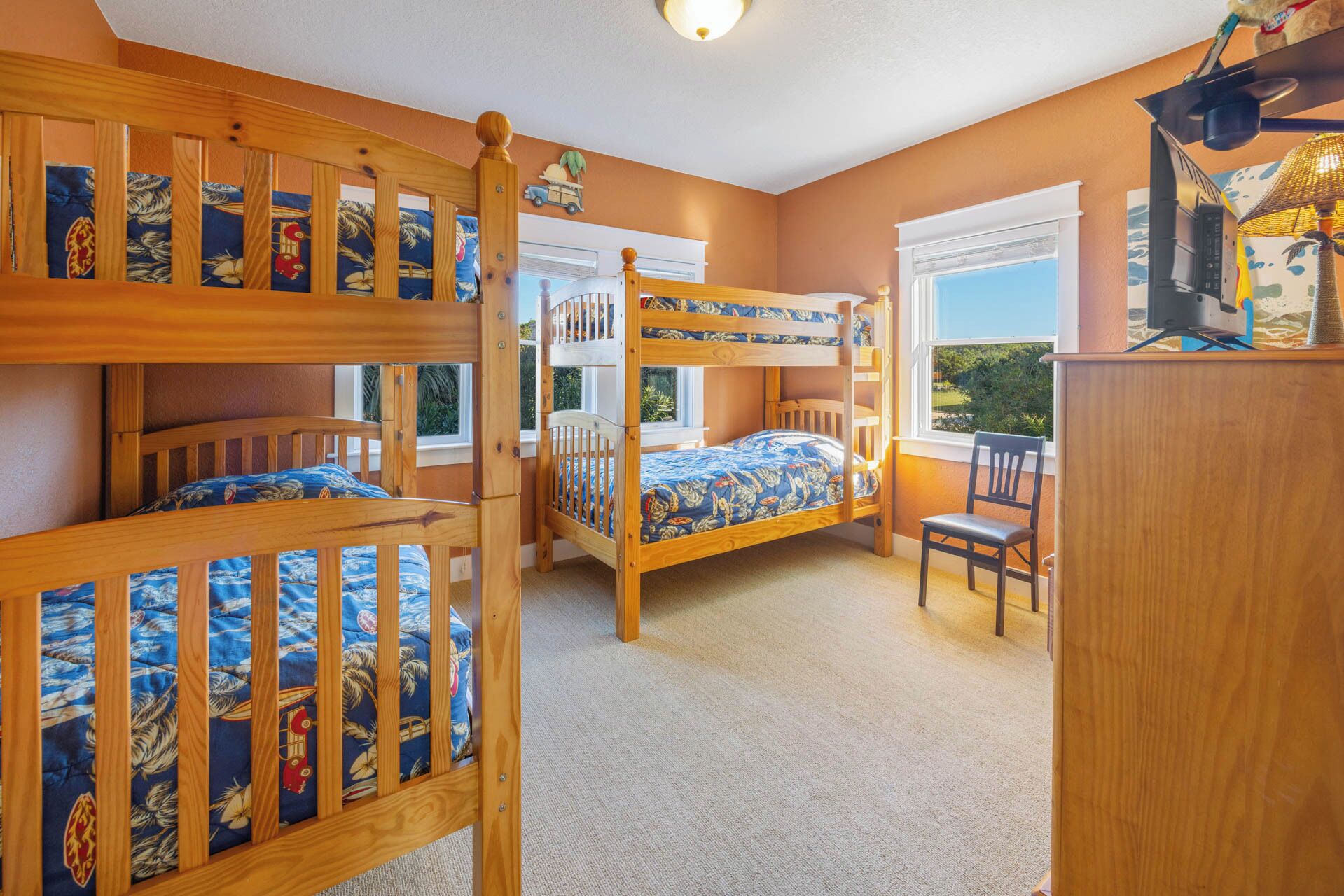 Une chambre avec des lits superposés, un bureau et une chaise.