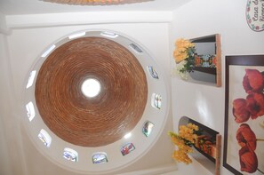 Ein rundes Oberlicht mit Backsteinmuster, umgeben von kleinen Fenstern.
