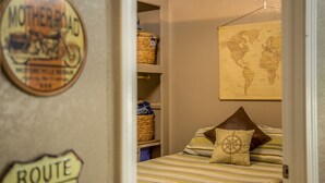 Un dormitorio con una cama, un mapa del mundo en la pared y un cartel en la puerta.