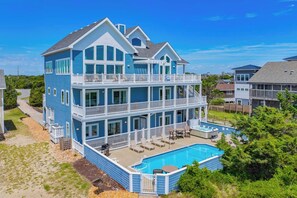 Ein mehrgeschossiges Haus mit einem großen Balkon und einem Schwimmbad.