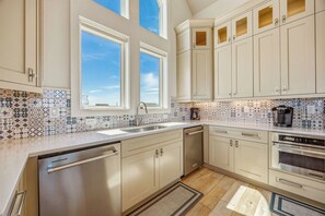 A modern kitchen with a dishwasher, oven, and coffee maker.