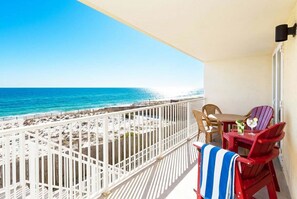 A balcony with a view of the beach and ocean, a table with chairs, and a small bar area. - Sea Dunes • Oceanfront Balcony w Convenient Direct Access, Pool, Hot Tub, Free Beach Service (Fort Walton Beach)