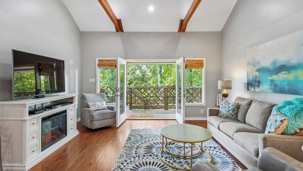 A spacious living room with a fireplace, a television, a sofa, and a dining table.