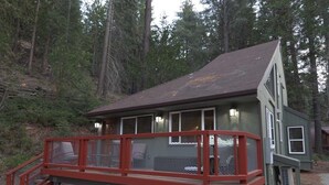 Uma cabana com deck vermelho e escadas que levam à entrada.