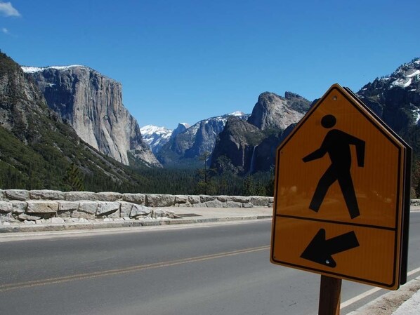 Señal de paso de peatones con montañas al fondo.