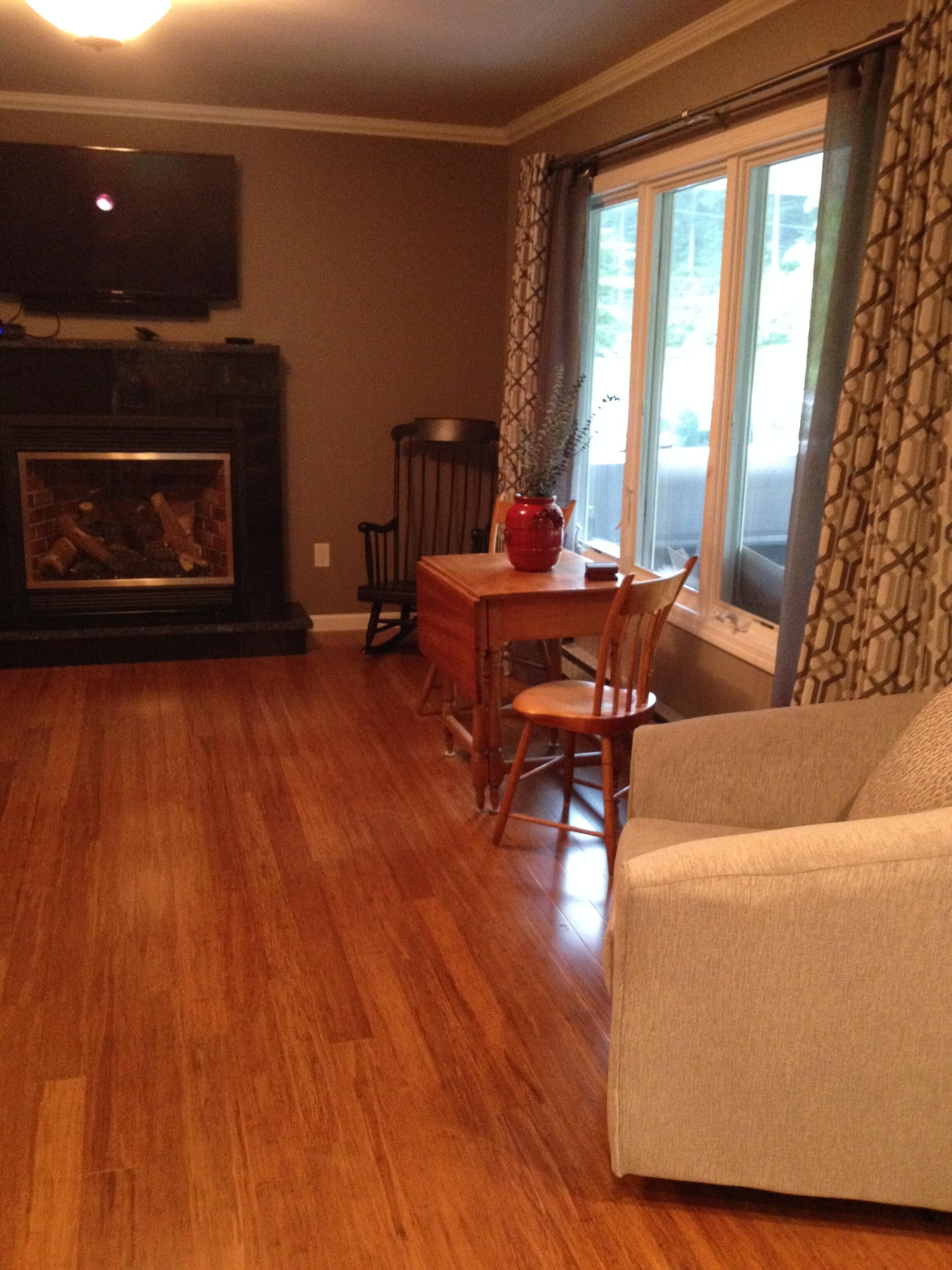 Large living room windows let in sunlight & look out on porch & front yard