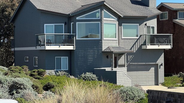 A two-story house with a grey exterior, multiple balconies, and a chimney. - Sweeping ocean views! Perfect for families, steps to sand, ping pong, Pickleball (Watsonville)