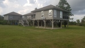 A two-story house with a covered porch and a staircase leading to an upper level.