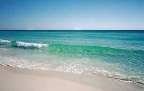 Een strand met helder turquoise water en een zandstrand.