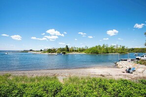 Søudsigt med både, en anløbsbro og en strand.