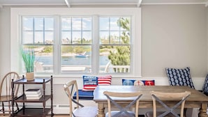 Un espace repas avec vue sur la mer, une table en bois et des chaises.