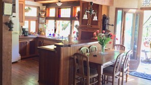 Un intérieur en bois comprenant un coin cuisine, une table à manger avec des chaises et une enseigne indiquant « KÖRJEKIA ».
