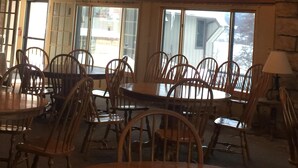 A dining area with wooden tables and chairs, large windows, and a high ceiling with exposed beams and hanging lights. - Newly remodeled, Located in Galena Territories. Small dogs OK under 25 LBS  (Galena)