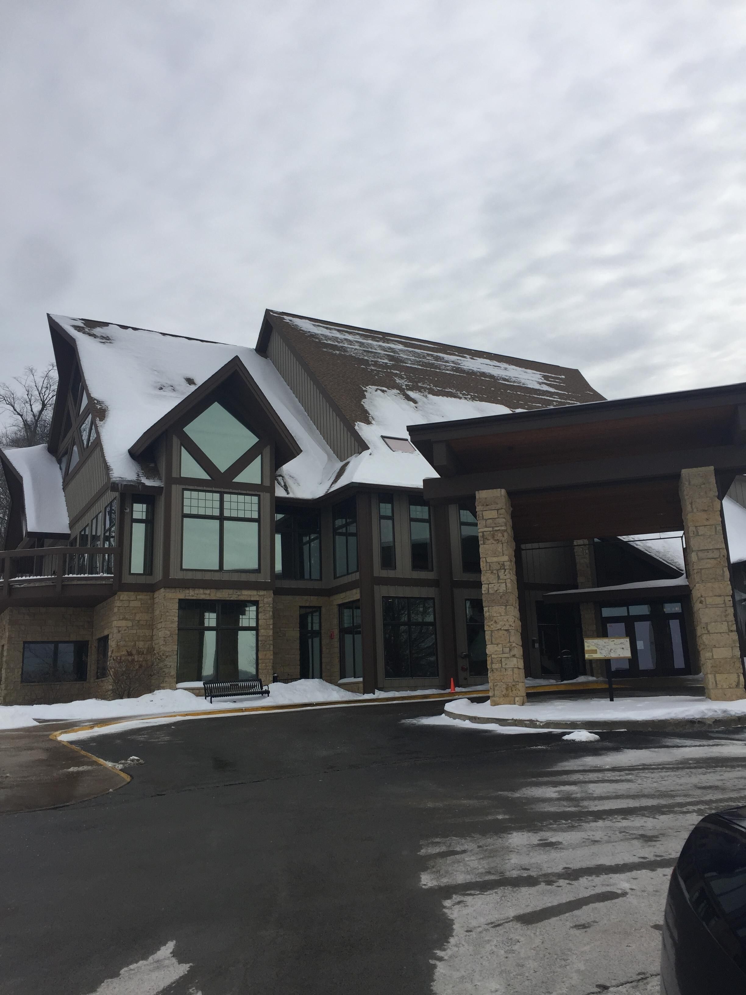A multi-story building with a snow-covered roof and large windows.