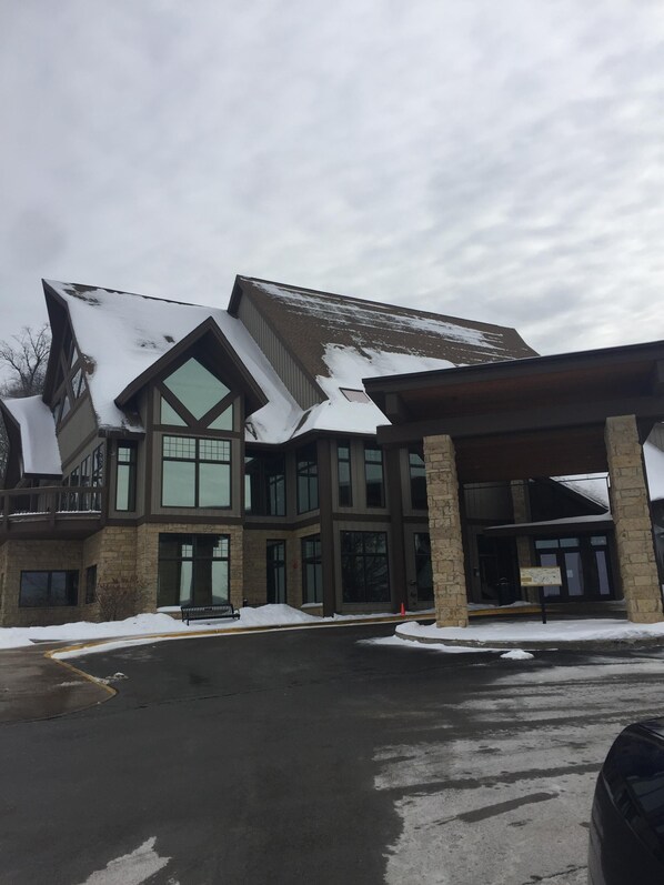 A multi-story building with a snow-covered roof and large windows.