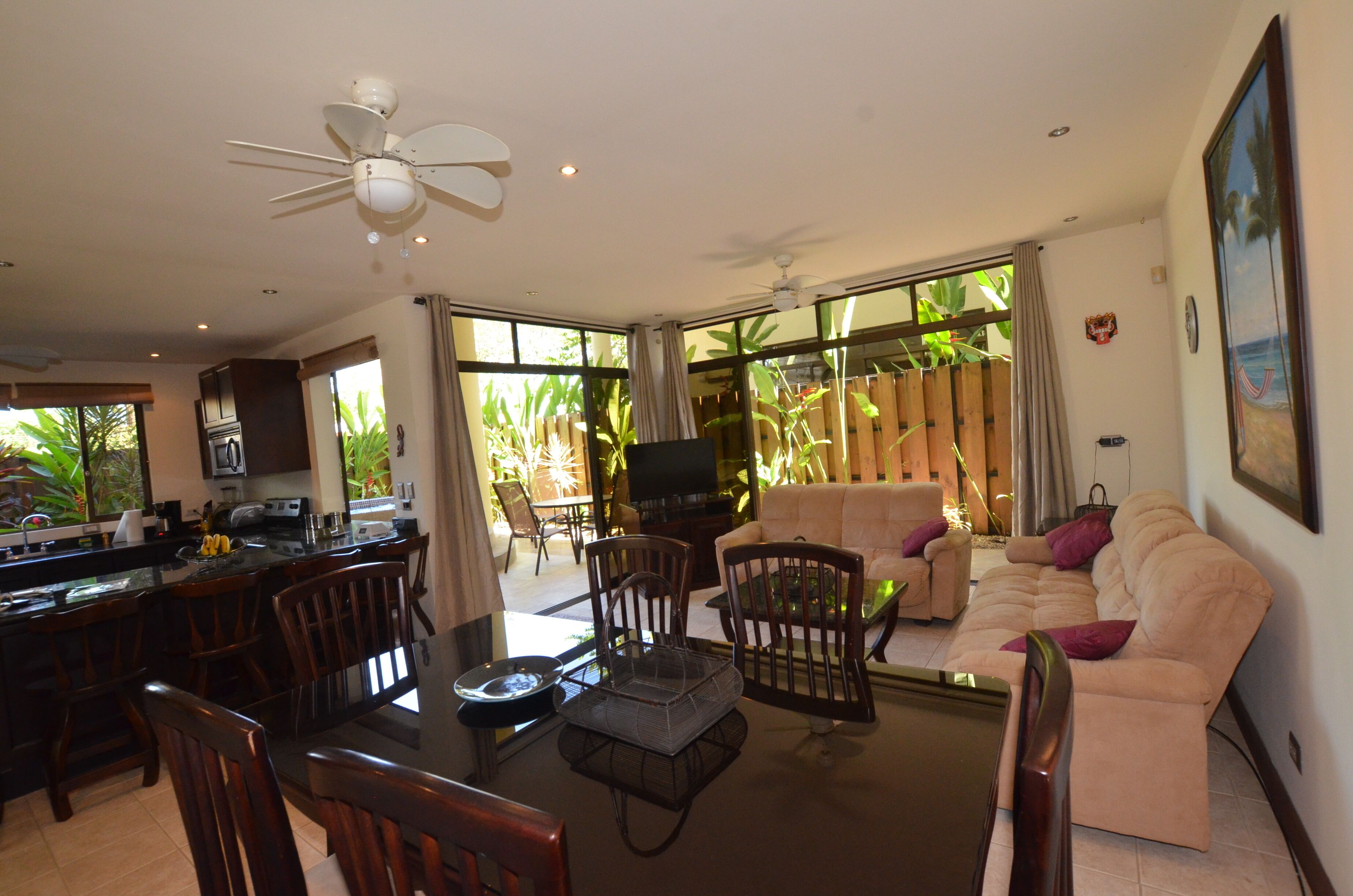 A spacious living area with a dining table, chairs, a sofa, and a television.