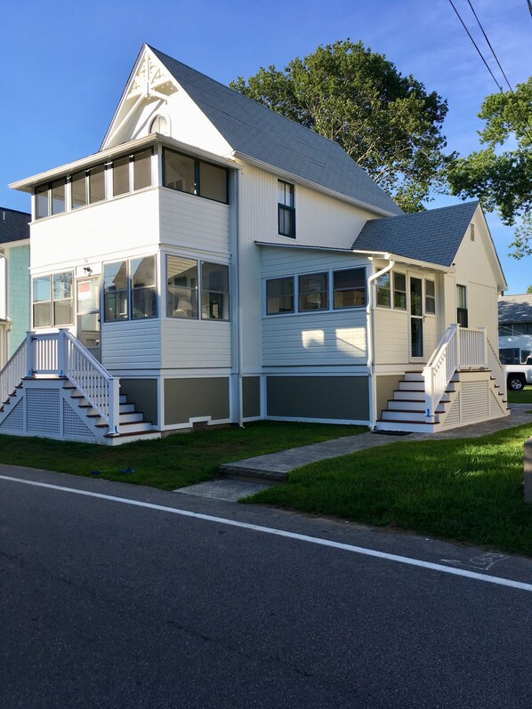 Ein zweistöckiges Haus mit Veranda und Garage.