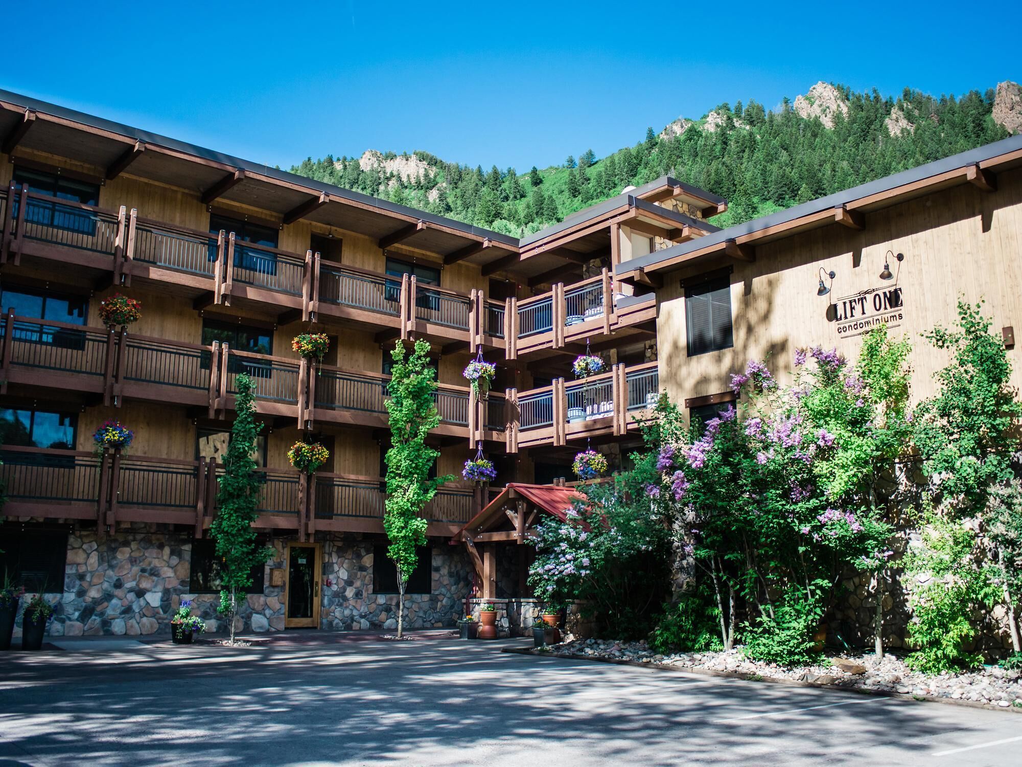 A multi-story building with balconies, a stone facade, and a sign for 'LIFT ONE condominiums'.