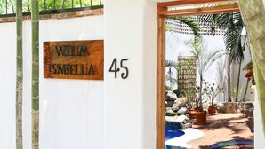 A villa named "Villa Isabella" with a number 45 sign, a small pool, and outdoor seating.