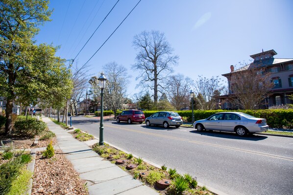 A street with cars, trees, and a sidewalk.