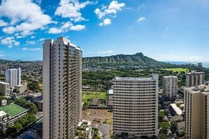 A high-rise building with multiple floors, surrounded by other buildings and greenery. - Ocean View Upgraded Waikiki Banyan (Honolulu)