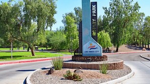 Un panneau indiquant « Lake Havasu City » et « Nord », entouré d’arbres et bordé d’une zone recouverte de gravier.