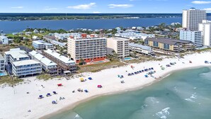 A coastal hotel with multiple buildings, a sandy beach, and a view of the sea.