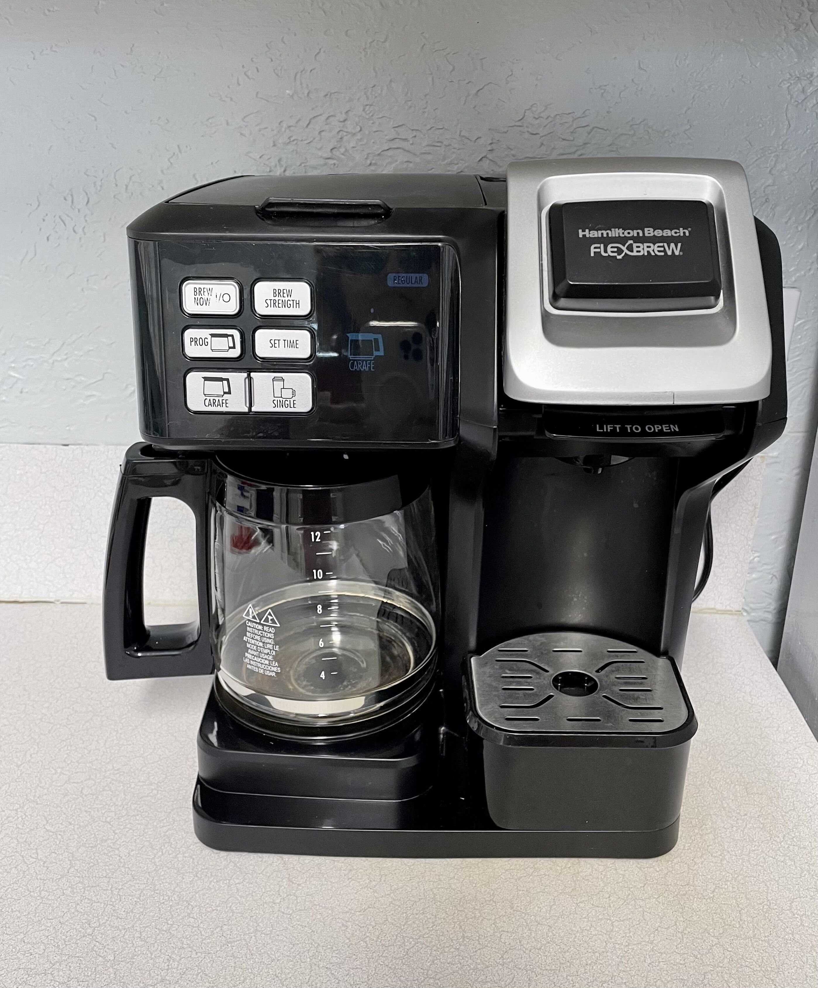 Una cafetera Hamilton Beach Flexbrew con jarra de vidrio y bandeja de goteo.