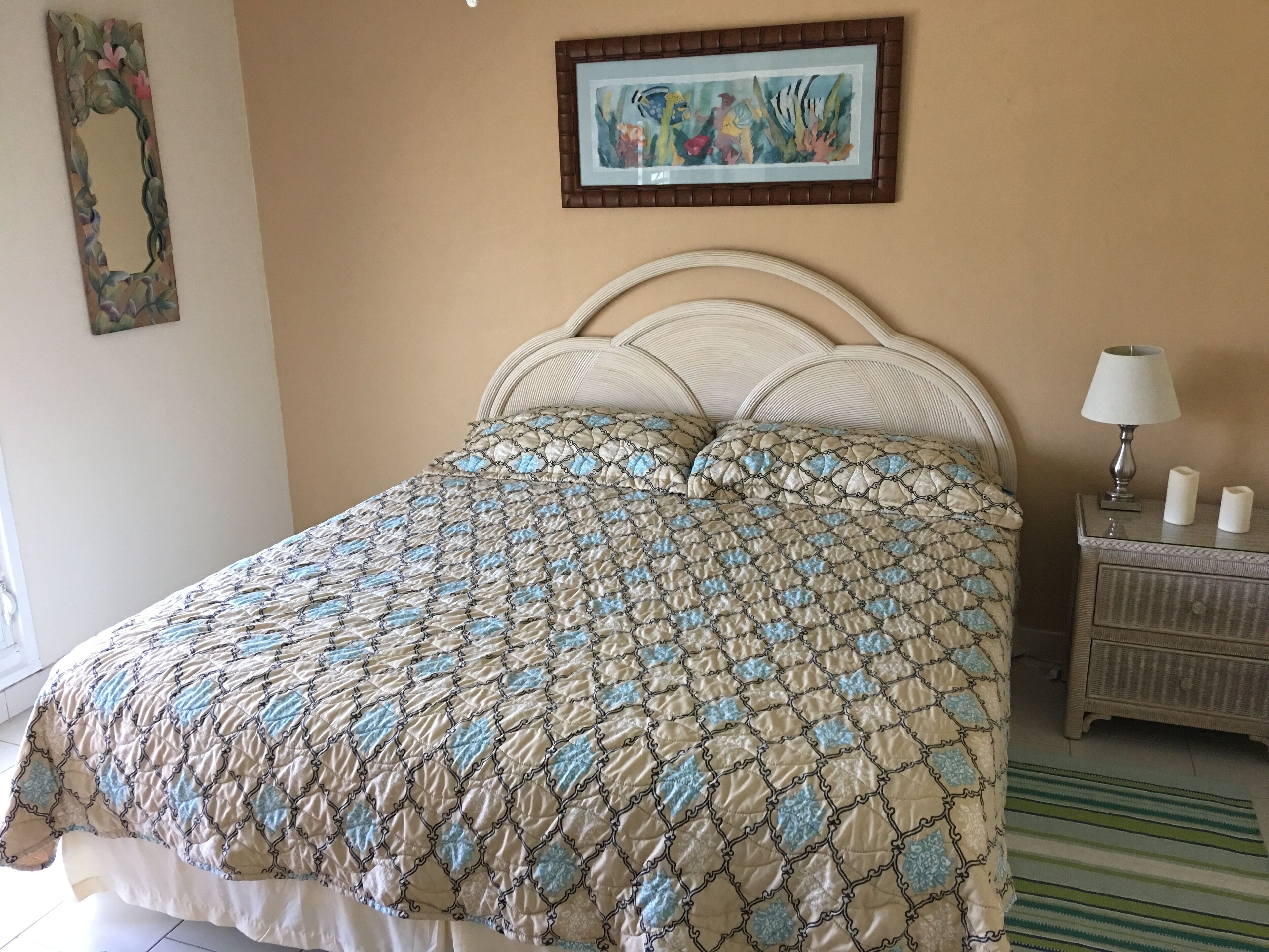 Una camera da letto con un letto, un comodino, una lampada e un quadro appeso al muro.