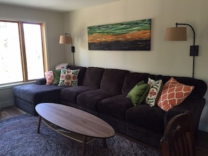 Relax in this stylish living room with a comfortable sofa, coffee table, and abstract art.