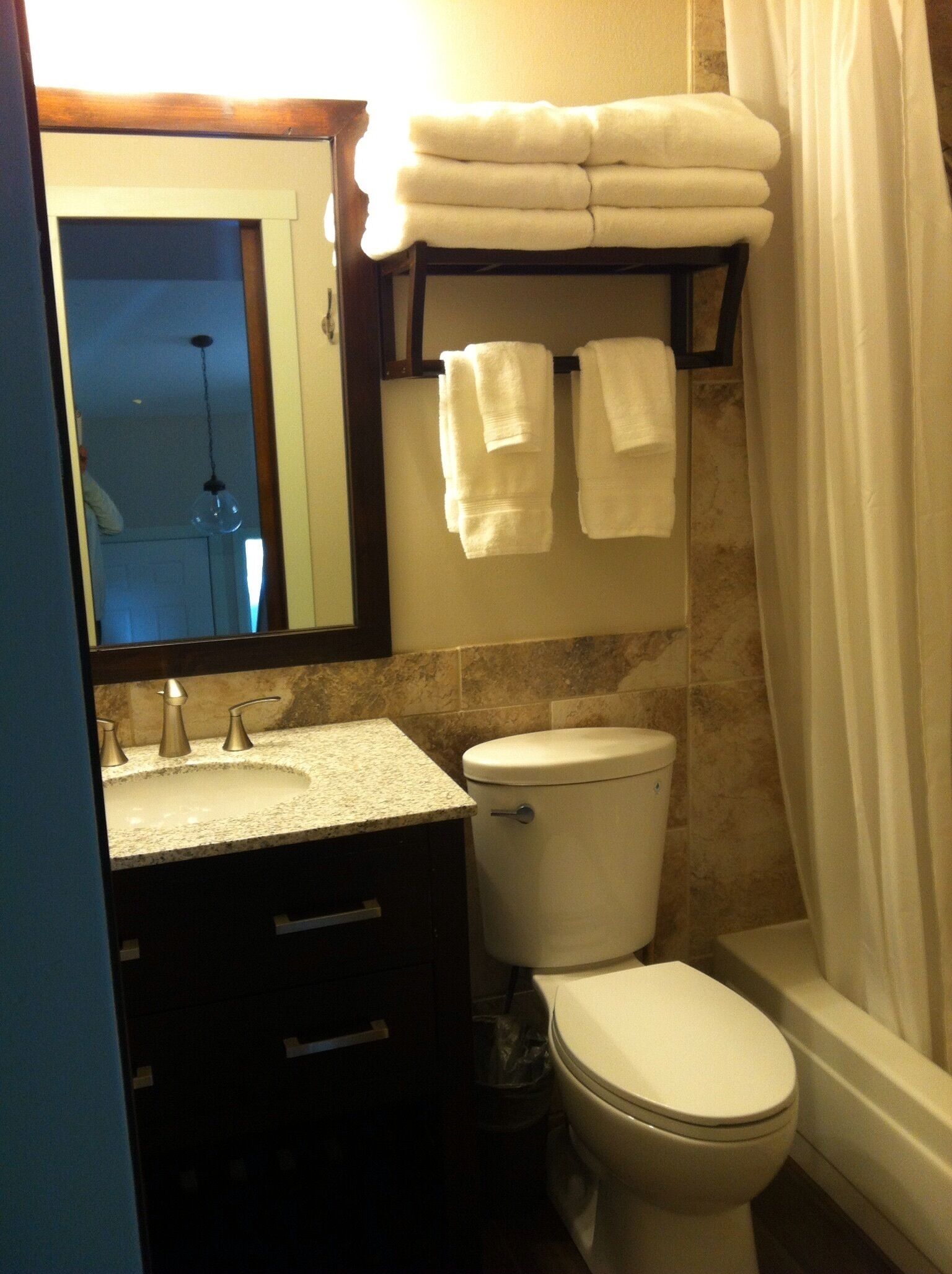 Une salle de bain équipée d’un lavabo, de toilettes et d’un porte-serviettes avec des serviettes pliées.