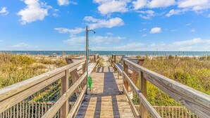 A wooden boardwalk leading to a beach with a clear sky. - Come on down! Great weather, comfortable furniture and beds! 
Best view! (Surfside Beach)
