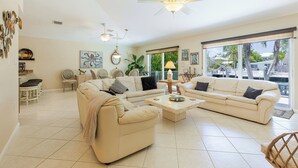 A spacious living room with two sofas, a coffee table, and a ceiling fan. - A Cut Above - 5 Star property that lives up to its name (Key Colony Beach)