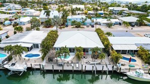 A coastal property with multiple swimming pools, a dock with boats, and a large central building. - A Cut Above - 5 Star property that lives up to its name (Key Colony Beach)